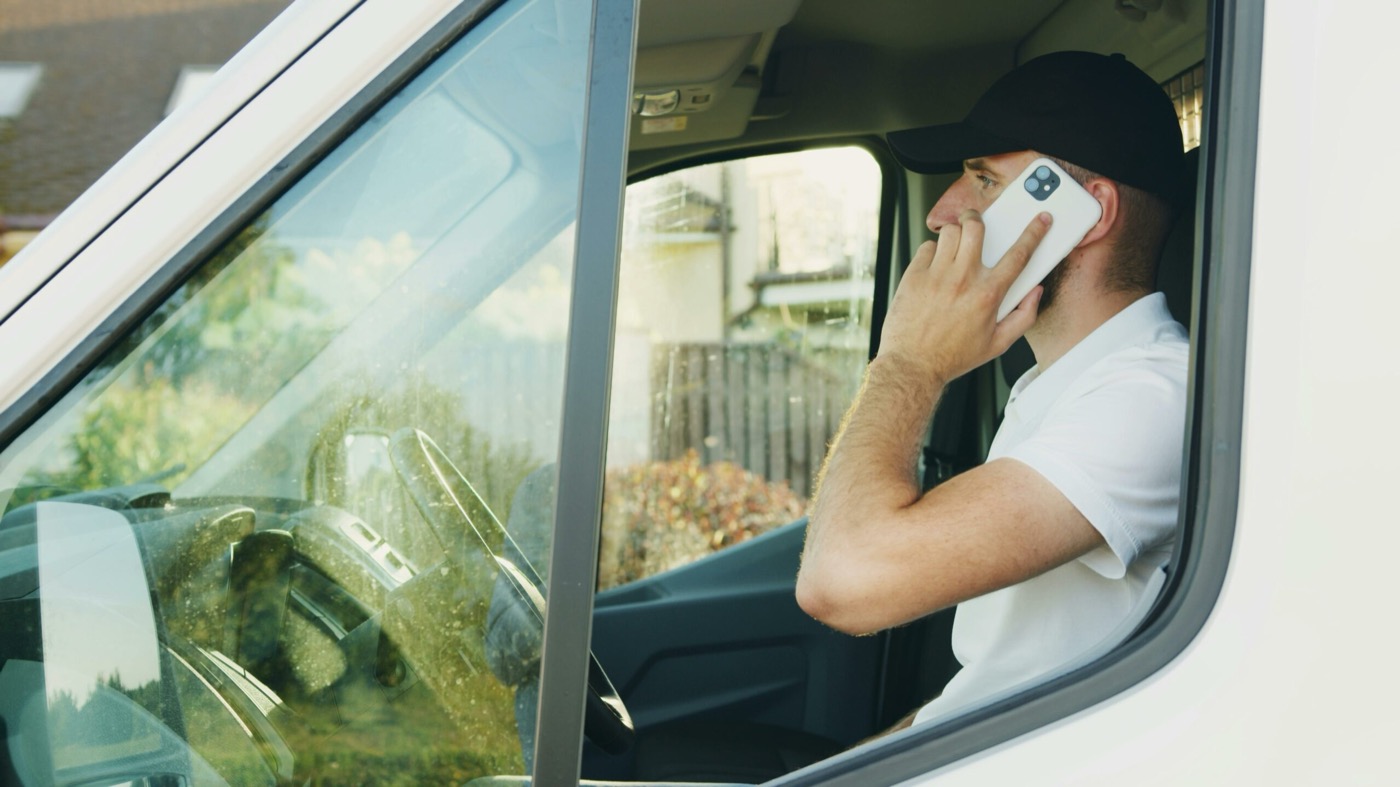 Chauffeur MT Courses au téléphone à bord de son véhicule