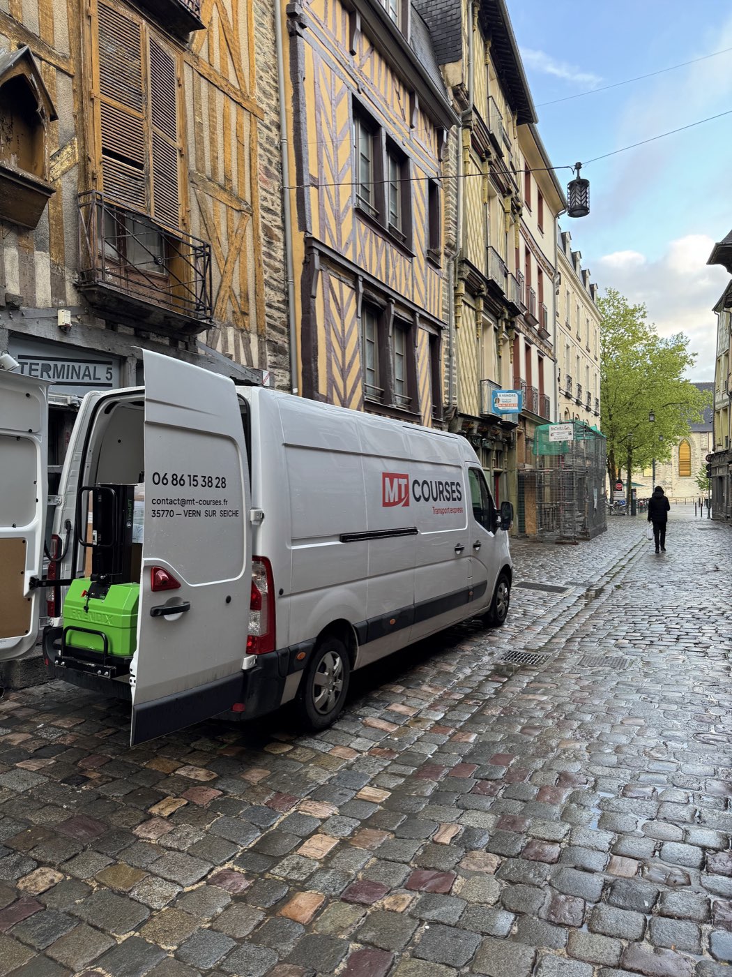 Fourgon MT Courses en livraison dans une rue pavée du centre-ville, portes ouvertes